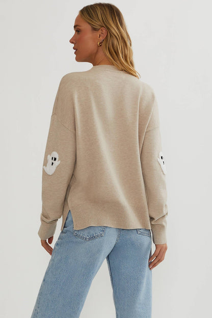 Rückansicht des beigen Pullovers mit seitlichen Schlitzen am Rippsaum und je einer weißen Geister-Applikation am Ellbogen. 5