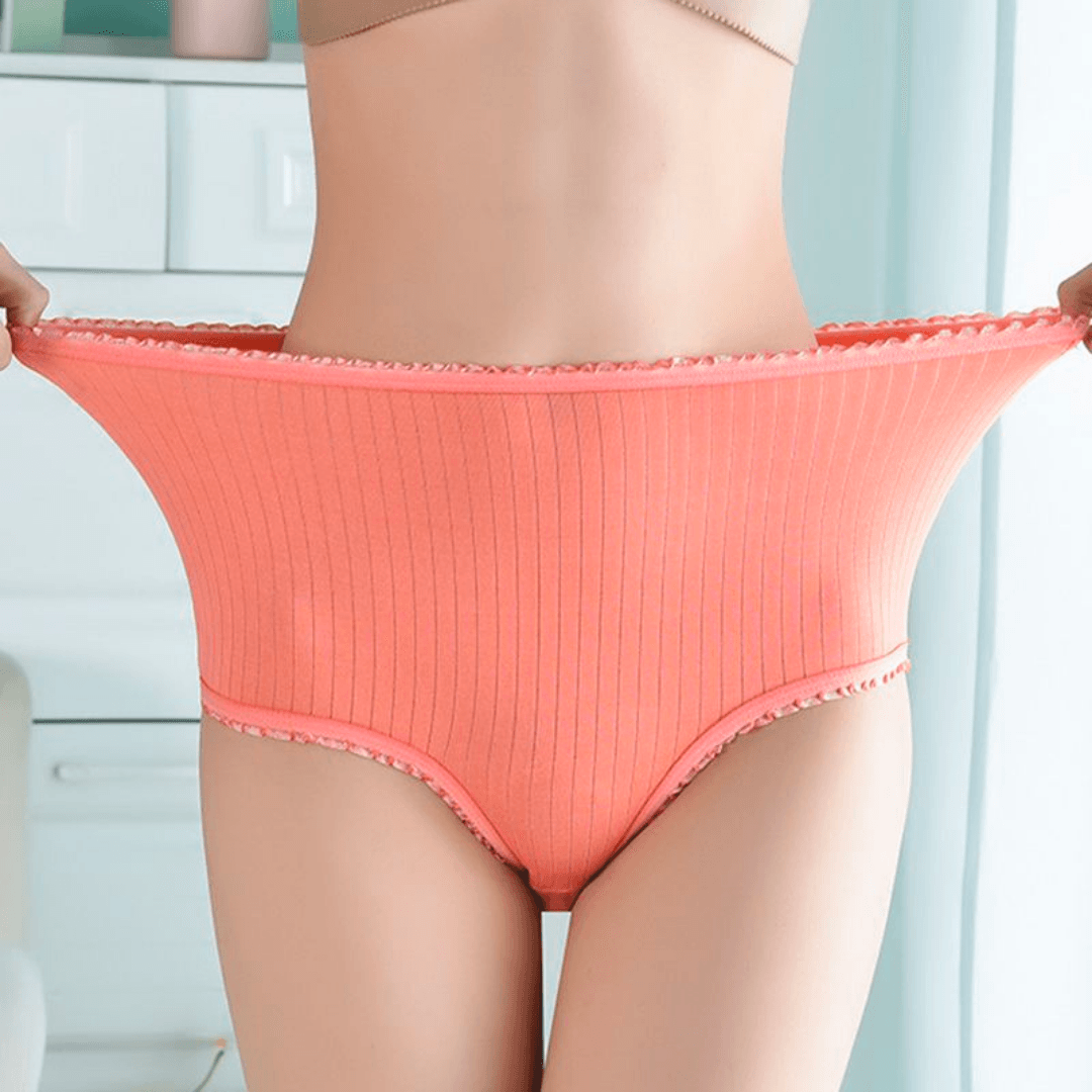 Hochgeschnittenes lachsfarbenes Ripp-Höschen mit Rüschensaum, vom Model an der Taille weit gedehnt, um die Elastizität zu zeigen. 1
