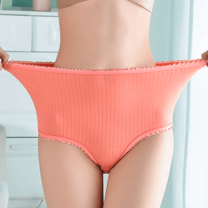 Hochgeschnittenes lachsfarbenes Ripp-Höschen mit Rüschensaum, vom Model an der Taille weit gedehnt, um die Elastizität zu zeigen. 1