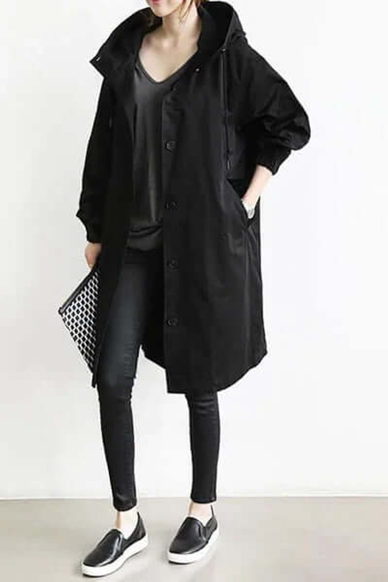 Schwarzer Mantel mit Kapuze, von vorn getragen zu schwarzer Hose, Slippern und gemusterter Clutch 3