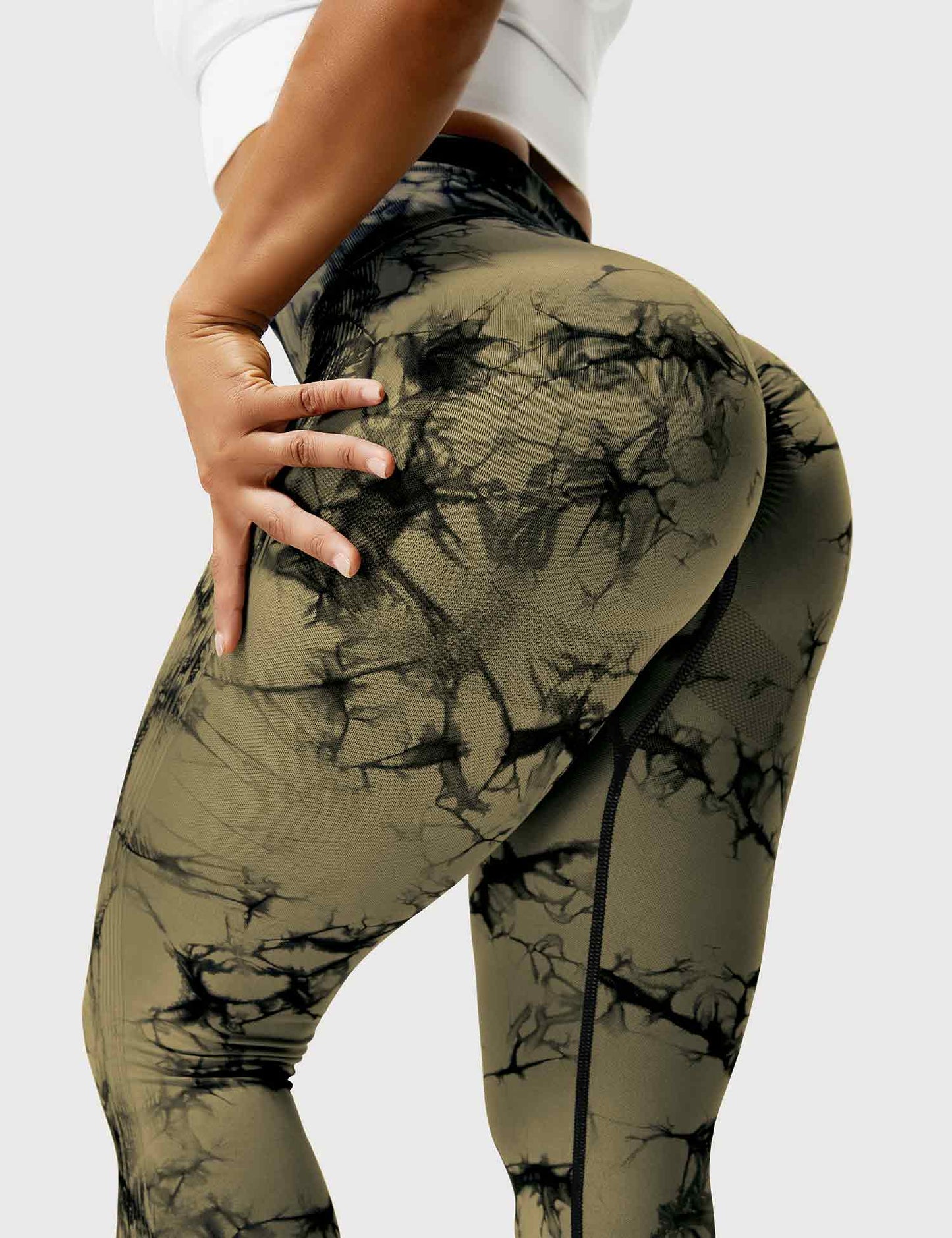 Frau in braunen Leggings mit schwarzem Marmor-Muster, Sportbekleidung, Fitnessmode.