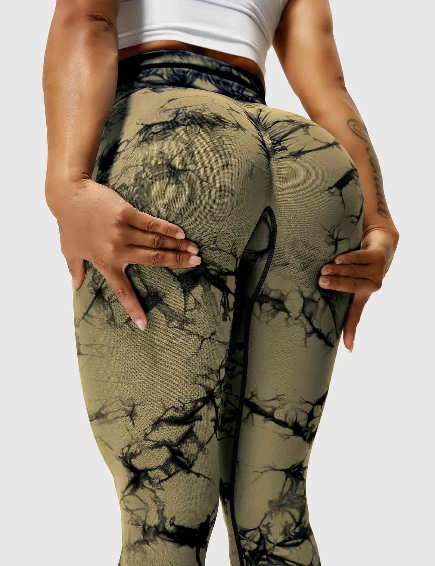 Frau in braunen, gemusterten Leggings, Sportbekleidung, Fitnessmode, elastisch, bequem.