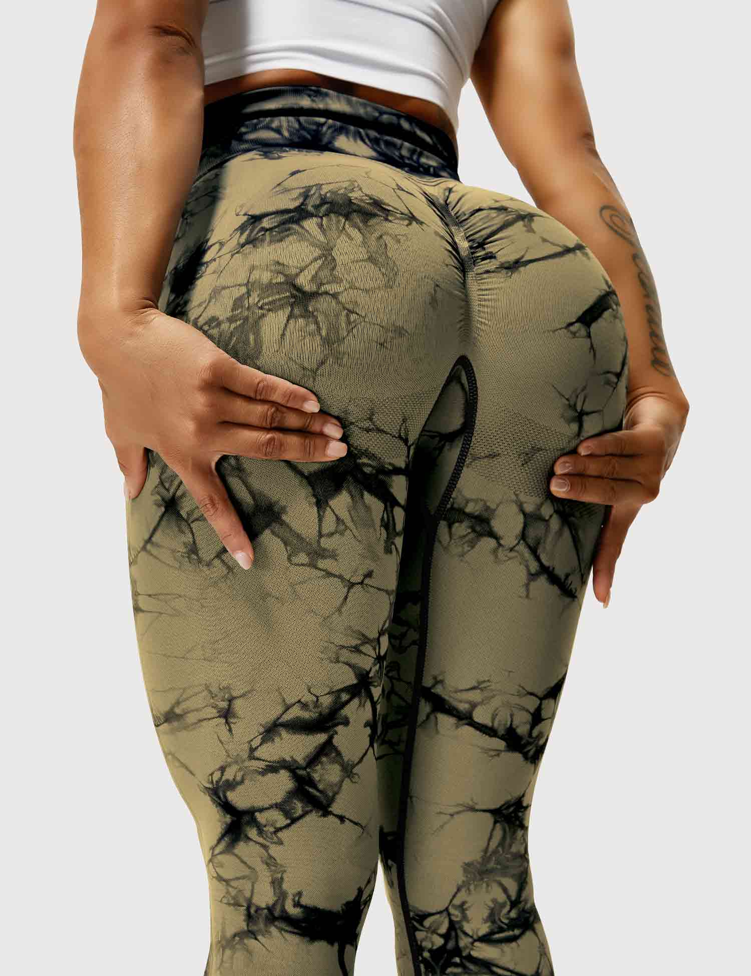 Frau in braunen, gemusterten Leggings, Sportbekleidung, Fitnessmode, elastisch, bequem.