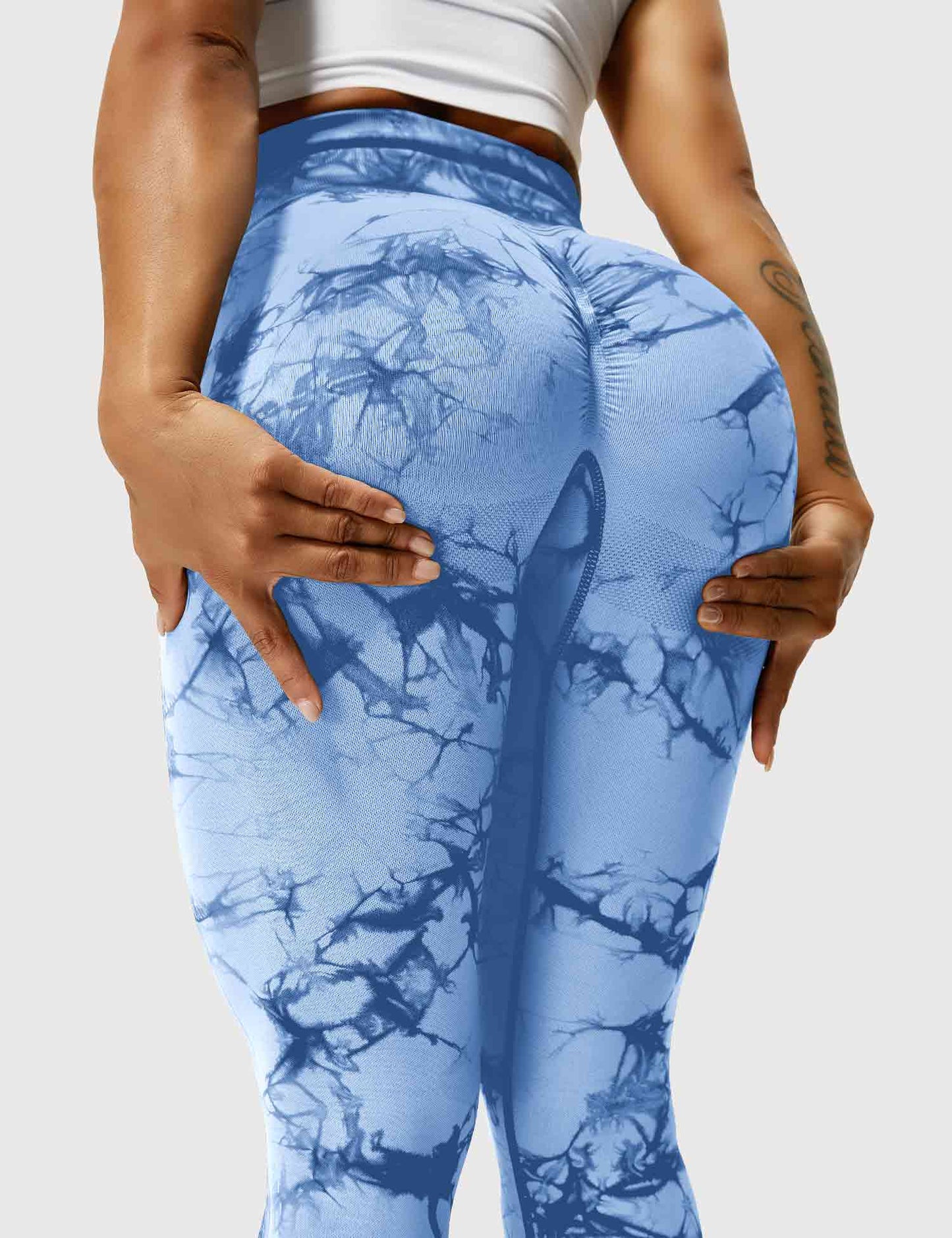 Frau in hellblauen Leggings mit Marmormuster, Sportbekleidung, elastisch, bequem.