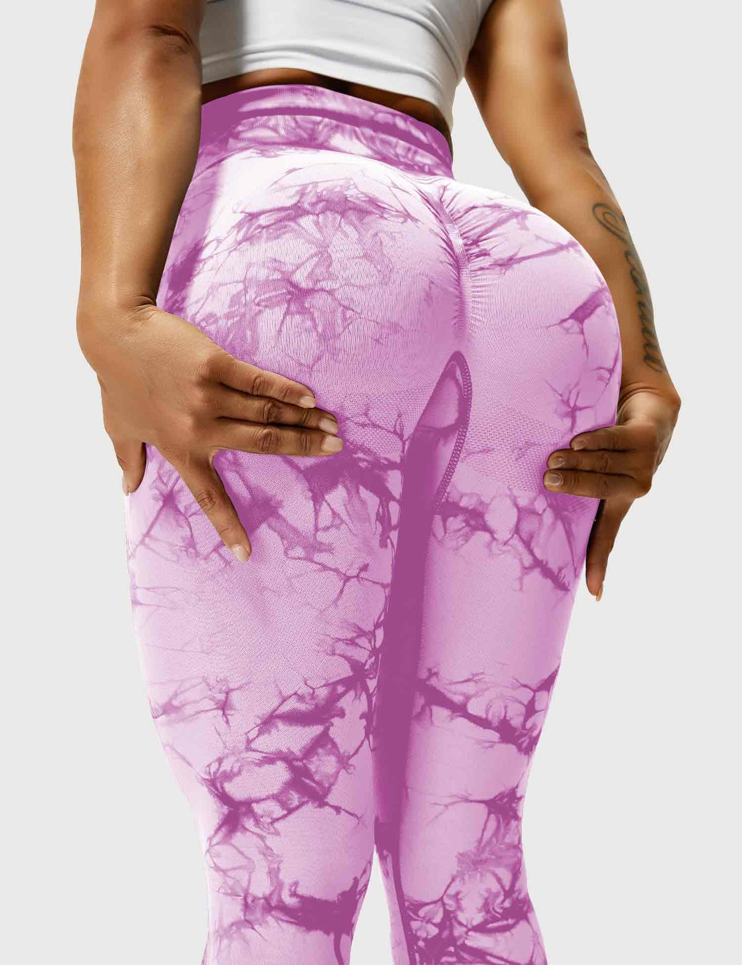 Frau in lila Leggings mit Marmormuster, Sportbekleidung, Fitnessmode, elastisch, bequem.