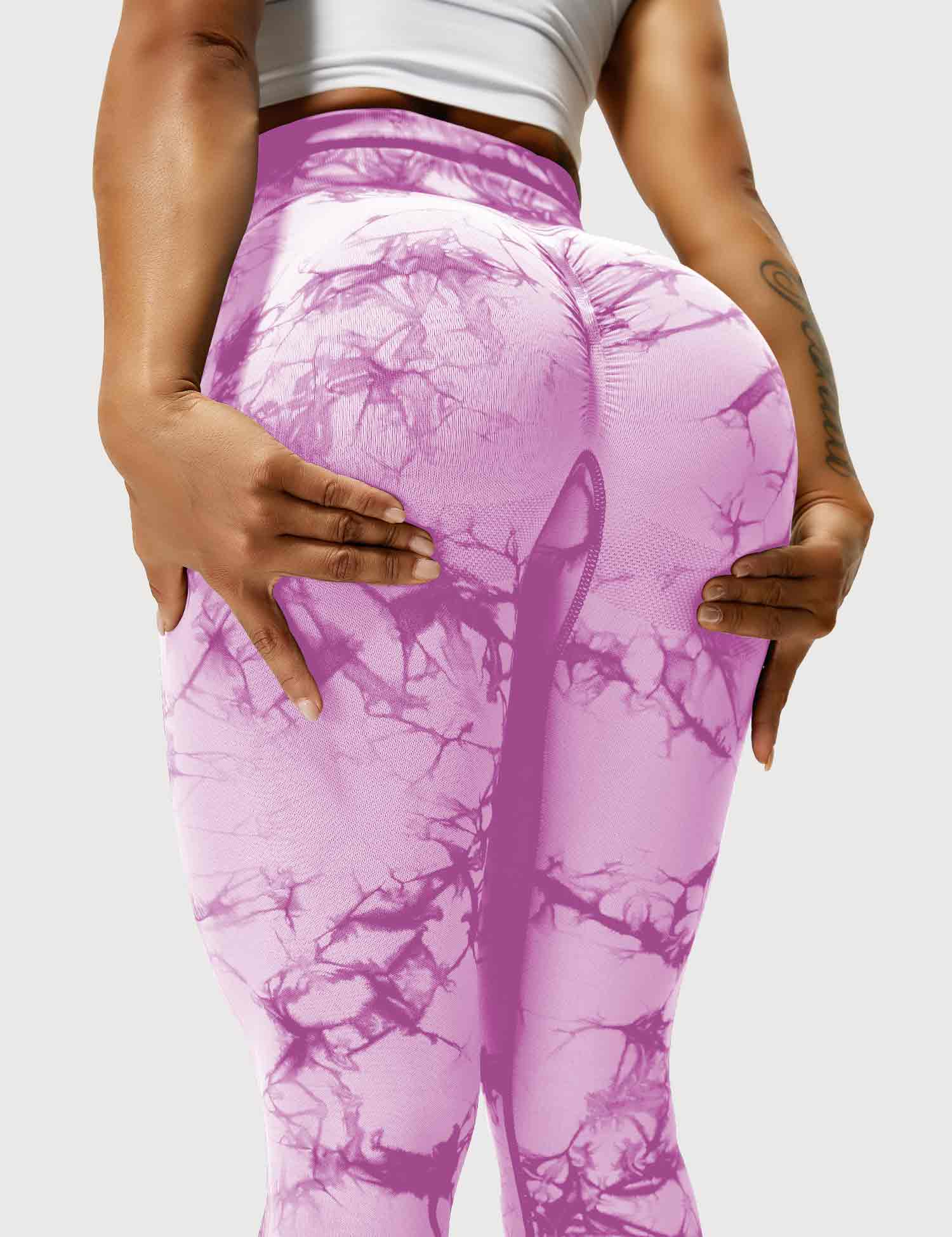 Frau in lila Leggings mit Marmormuster, Sportbekleidung, Fitnessmode, elastisch, bequem.