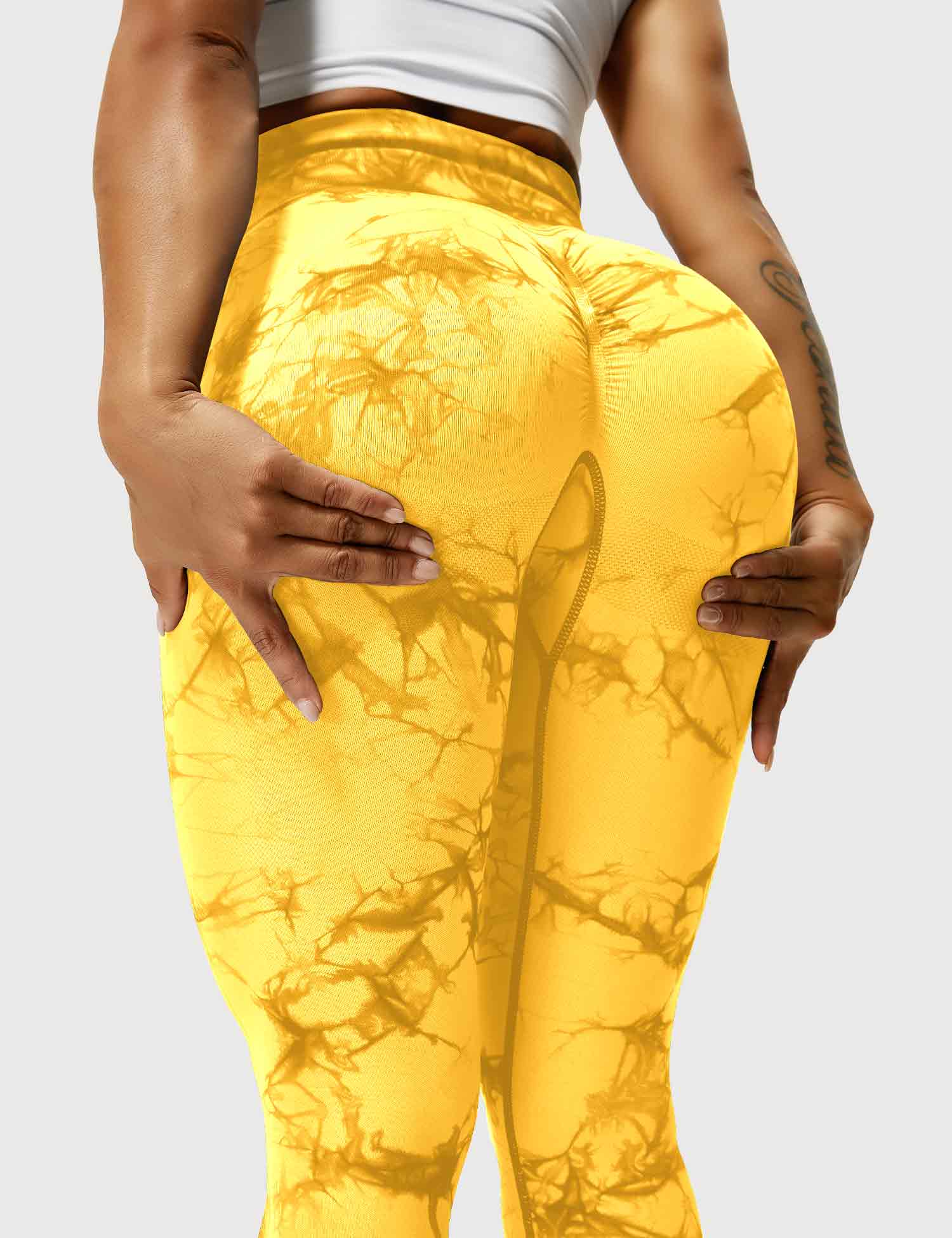 Frau in gelben Leggings mit Marmormuster, Sportbekleidung, Fitnessmode, elastisch, bequem.