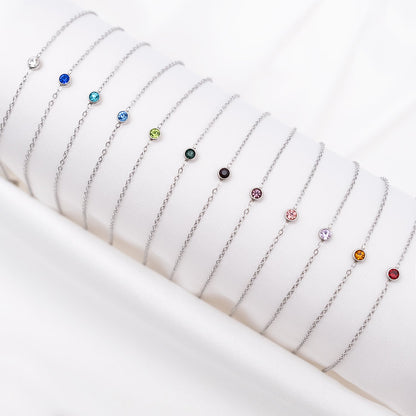 Silberne Geburtsstein-Armbänder auf weißem Hintergrund, verschiedene Farben, Schmuck für Damen.