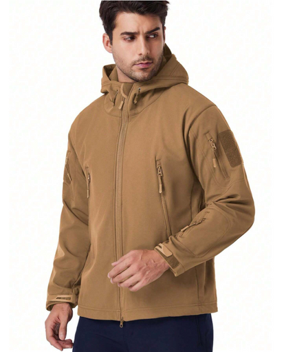 Mann in der beigen Kapuzenjacke, seitlich blickend, mit Brusttaschen, Ärmeltasche, Klettfläche am Oberarm und durchgehendem Reißverschluss. 16