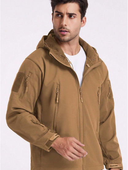 Mann trägt die beige Jacke offen über weißem T-Shirt; Fleecefutter an Kapuze und Kragen sowie Taschen sind sichtbar. 17